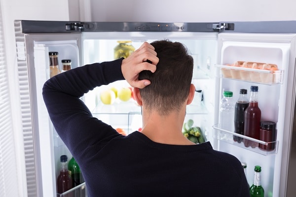 man in front of KitchenAid fridge that is not cooling