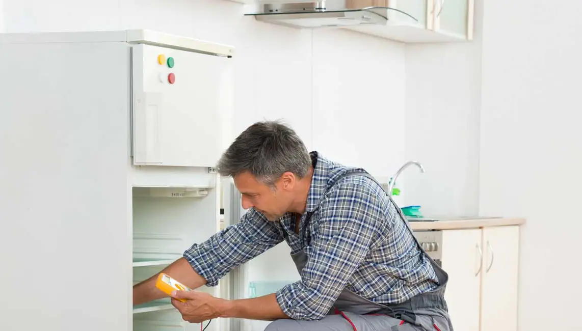 Technician checking a refrigerator in a New York apartment